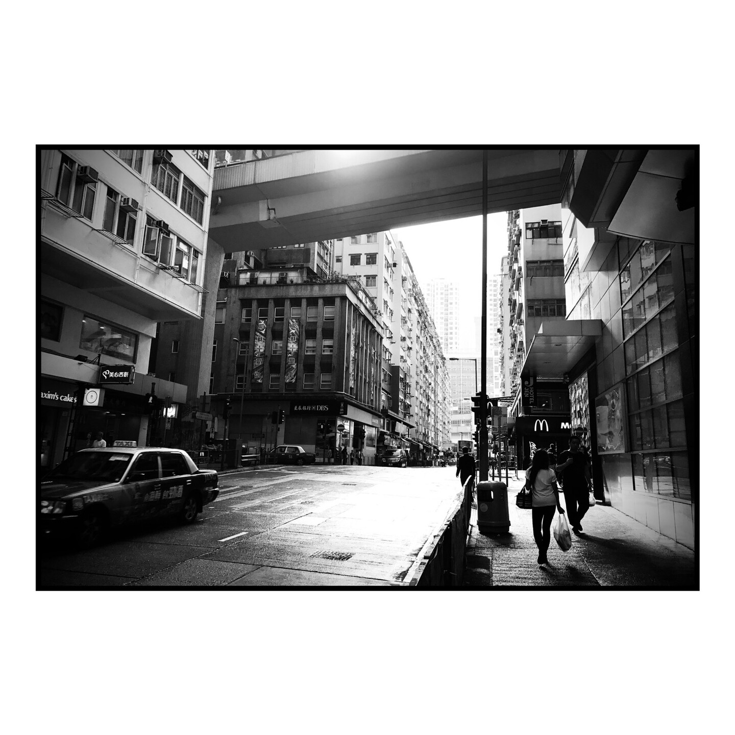 A taxi drives by a street scene in downtown Hong Kong 
