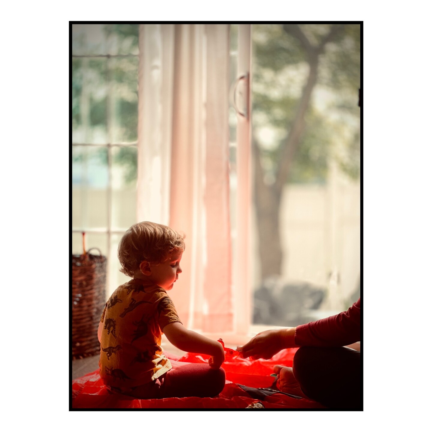 Our son sitting in the floor near a sliding glass door. 