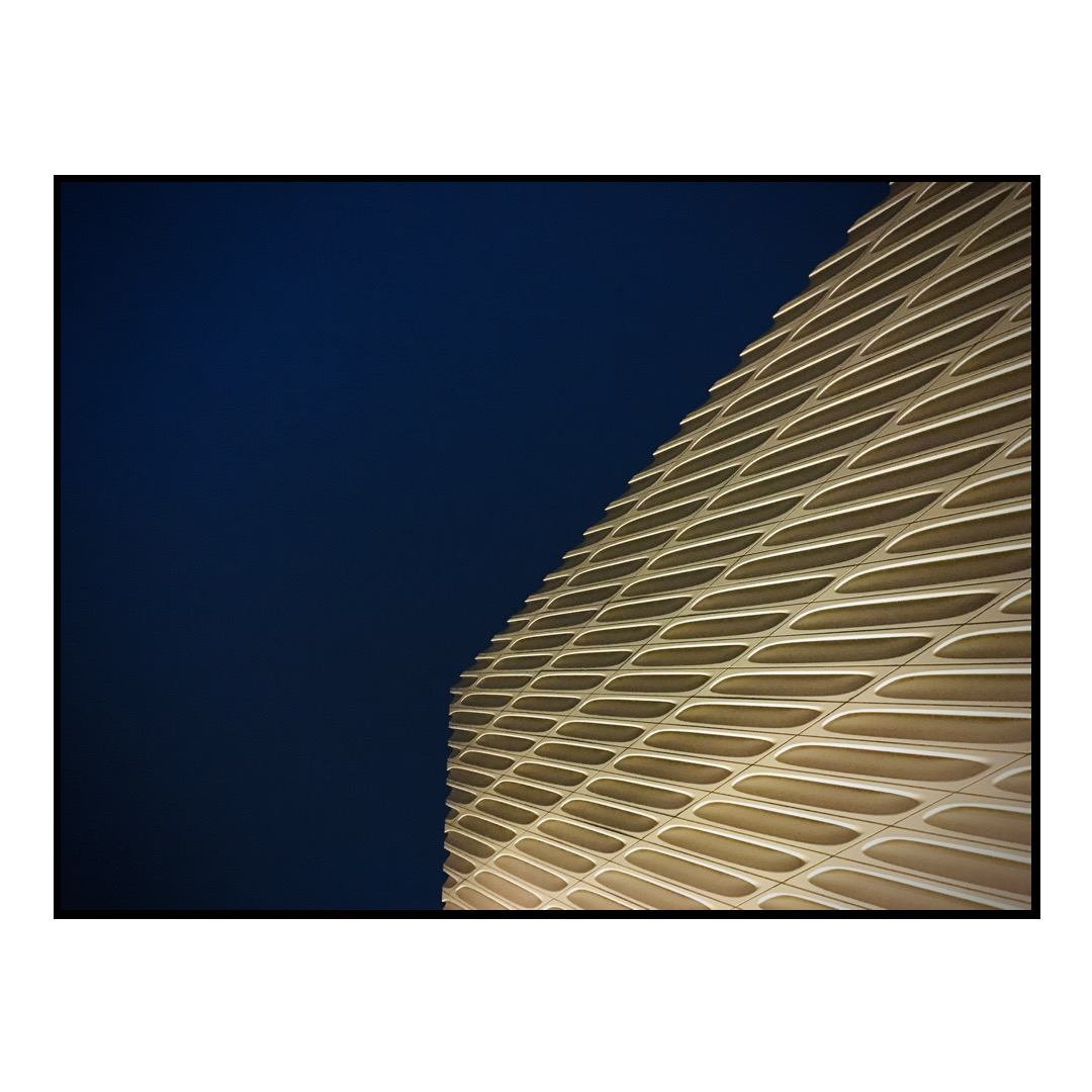 A view of The Broad art museum against a blue sky.