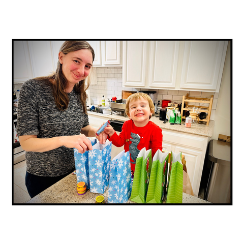 Mon and son standing in the kitchen filling goodie bags for Christmas.