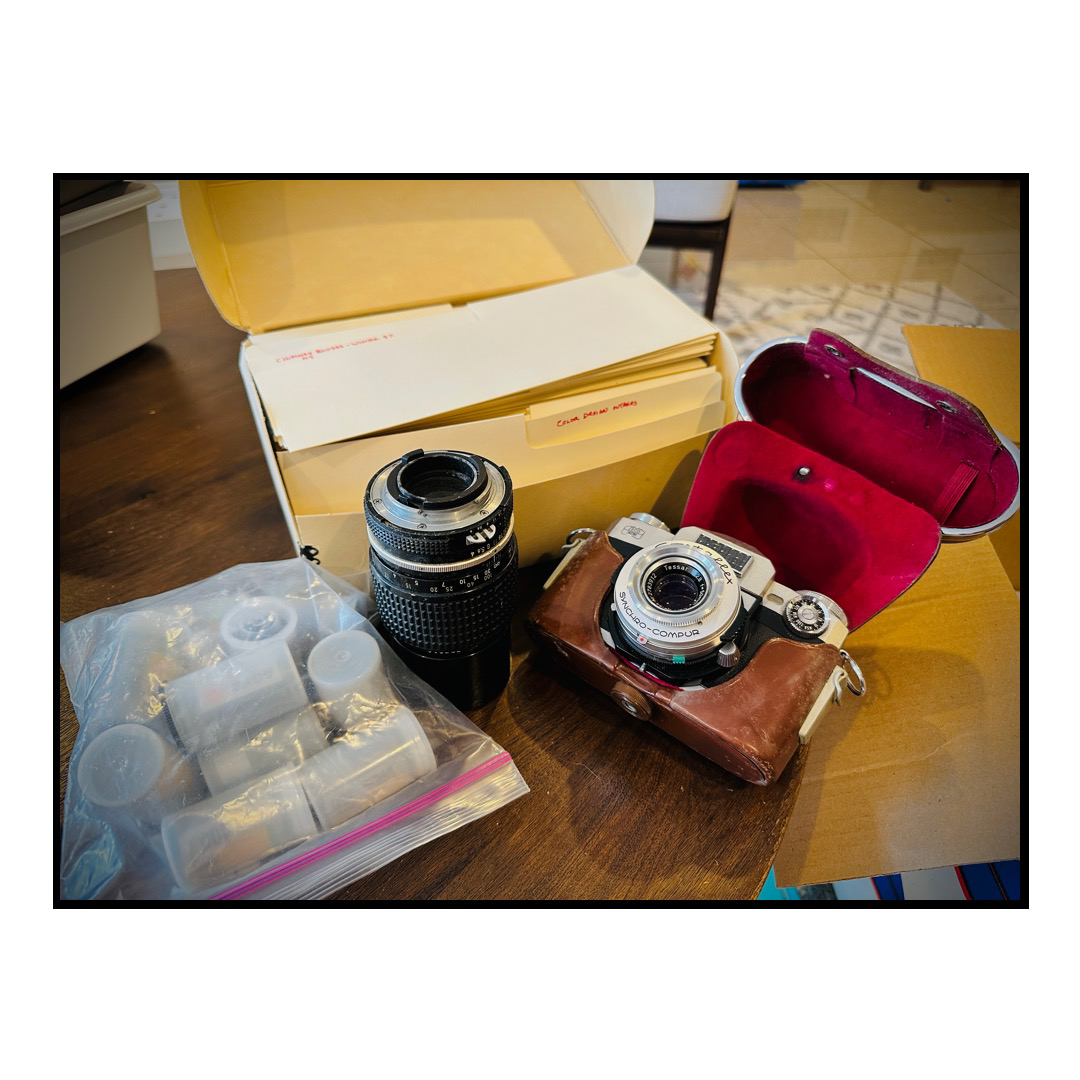 An old camera and film on a coffee table