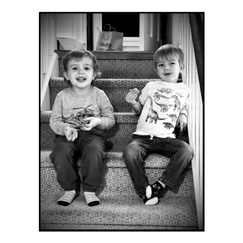 Black and white photo of our son and his friend sitting on the steps 