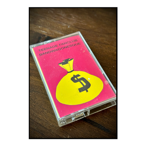 A bright pink and yellow cassette tape on a coffee table.