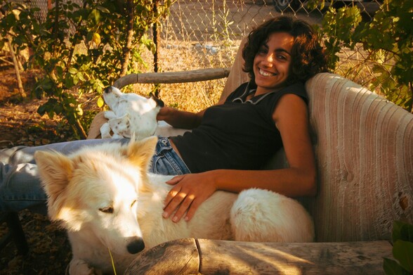 Anat sitting in her garden near Jerusalem with her two dogs.