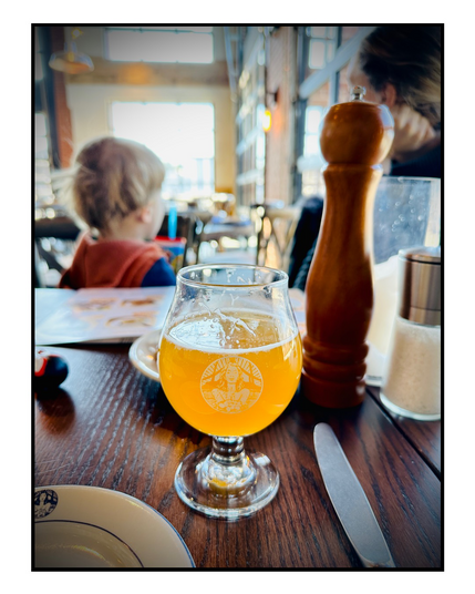 A yellow lint of beer on a table at a brewery.