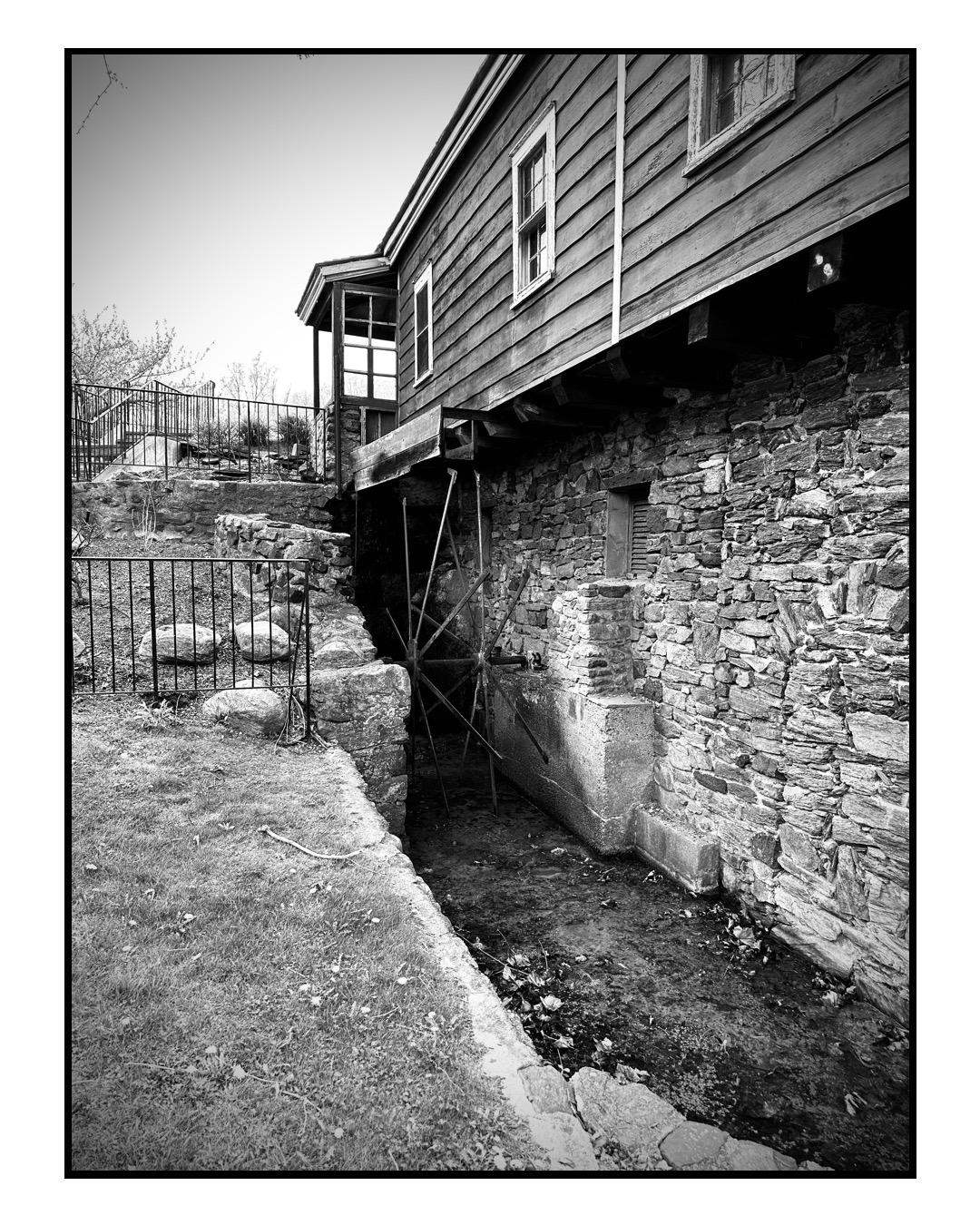 Black and white photo of an old mill water wheel.
