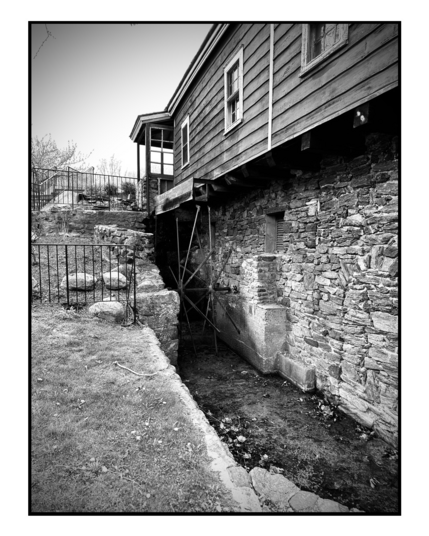 Black and white photo of an old mill water wheel.