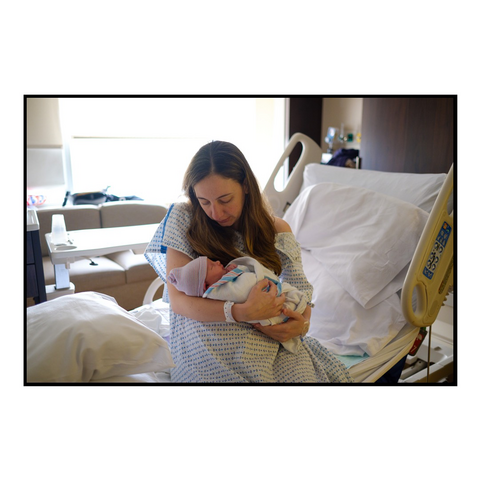 A woman in a hospital bed holding her new baby