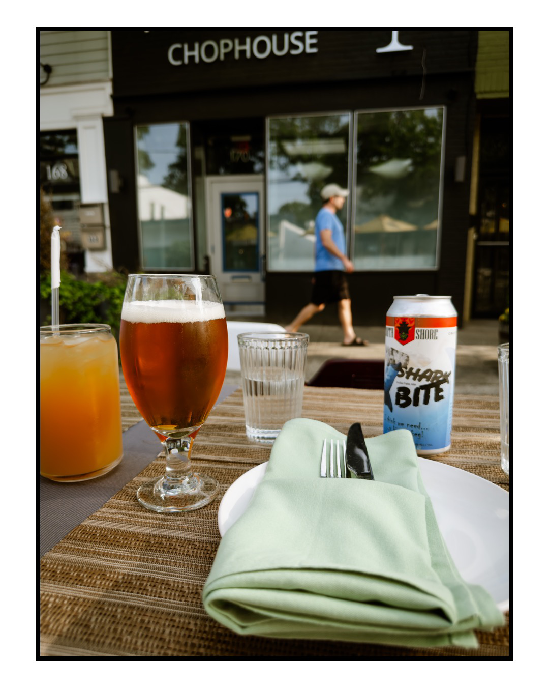 Color photo of a beer glass and can on an outdoor table 